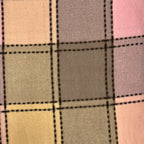 Close-up of a plaid fabric with a checkered pattern in beige, gray, and pink.